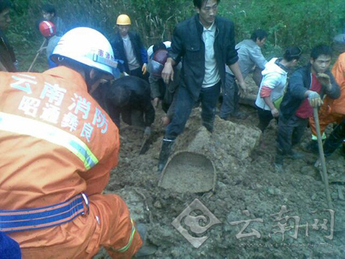 Nhân viên cứu hộ và dân làng đào bới trong đống đất đá để tìm kiếm nạn nhân